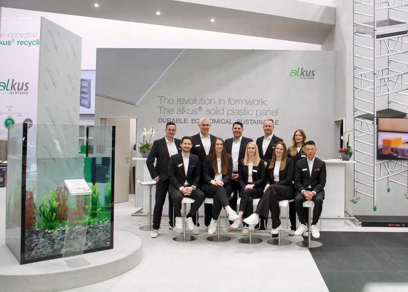 Ein Aquarium als Hingucker: Das Alkus-Team mit dem neuen Geschäftsführer Daniel Keller (hinten, 3.v.l.) und Inhaber Julian Dingler (hinten, 2.v.r.). | Foto: alkus AG/Jens Ellensohn