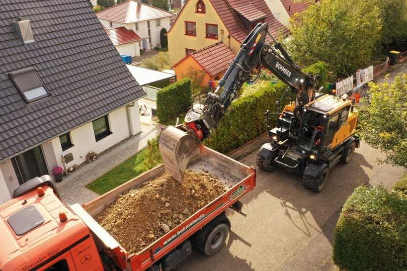 Sanierung von Abwasserkanal und Hausanschlüssen in Röttingen. Nur Kurzheckbagger schaffen die LKW-Beladung in dieser typischen schmalen Wohnstraße. | Foto: Hyundai/OBA Sanierung von Abwasserkanal und Hausanschlüssen in Röttingen. Nur Kurzheckbagger schaffen die LKW-Beladung in dieser typischen schmalen Wohnstraße. | Foto: Hyundai/OBA