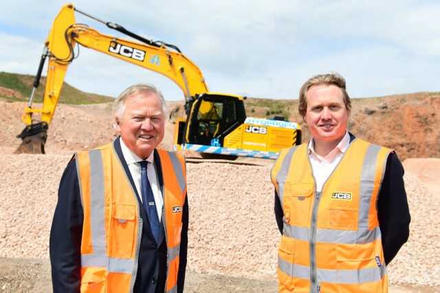 Lord Bamford zusammen mit seinem Sohn Jo vor dem Prototyp des 20 Tonnen JCB 220X Baggers mit Wasserstoffantrieb. | Foto: JCB