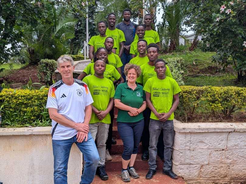 Freuen sich gemeinsam mit den erfolgreichen Absolventinnen und Absolventen im Projekt „Azubi-Gewinnung Kenia": Oliver Lindholz (vorn links), Ausbilder und Bauleiter bei der Firma Endlich Garten- und Landschaftsbau, Susann Liebe (vordere Reihe), Willkommenslotsin beim VGL Bayern, und Sem Haikali (ganz hinten), Ausbilder bei der DEULA Bayern. | Foto: Kiambu National Polytechnic/Owiye 