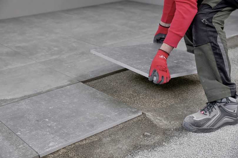 Im zweiten Schritt werden die unterseitig mit der Haftschlämme TNH versehenen Platten in die Bettung gelegt. | Foto: tubag Im zweiten Schritt werden die unterseitig mit der Haftschlämme TNH versehenen Platten in die Bettung gelegt. | Foto: tubag