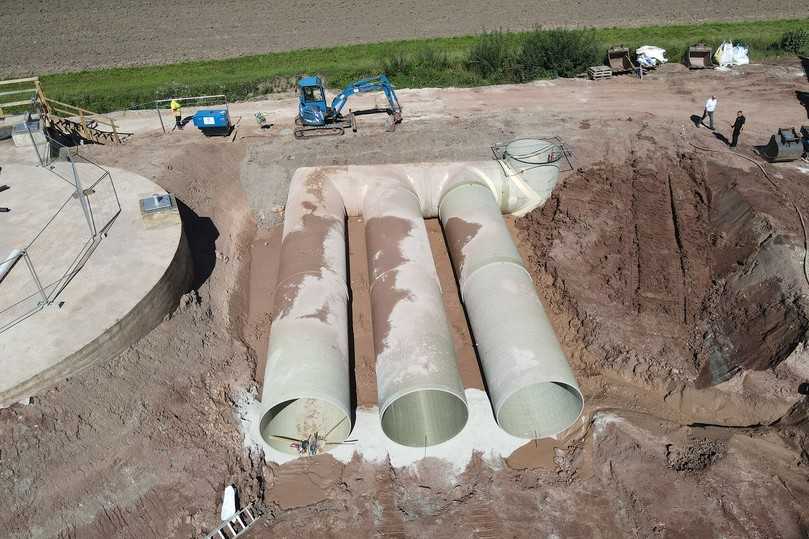 Jeweils 24,75 m lang sind die drei GFK-Rohre von Amiblu, die zukünftig das Speichervolumen des Regenüberlaufbeckens im oberfränkischen Markt Küps vorhalten. Hinten rechts zu sehen ist der Verteilerschacht, ebenfalls aus glasfaserverstärktem Kunststoff der Nennweite DN 2600. | Foto: Amiblu Jeweils 24,75 m lang sind die drei GFK-Rohre von Amiblu, die zukünftig das Speichervolumen des Regenüberlaufbeckens im oberfränkischen Markt Küps vorhalten. Hinten rechts zu sehen ist der Verteilerschacht, ebenfalls aus glasfaserverstärktem Kunststoff der Nennweite DN 2600. | Foto: Amiblu