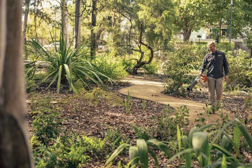Herabfallende Blätter bläst ein Mitarbeiter mit dem Stihl Akku-Laubbläser BGA 250 vom sich durch die Drylands schlängelnden Weg und ermöglicht den Besuchern so eine barrierefreien Aufenthalt. | Foto: Stihl