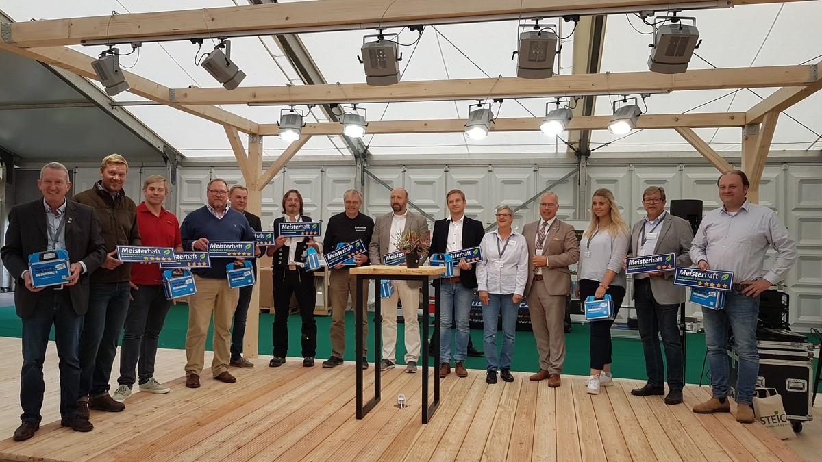 Zehn Meisterbetriebe wurden gestern auf der Messe mit dem neuen Nachhaltigkeits-Zertifikat ausgezeichnet. Thorsten Freiberg, Vorstandsvorsitzender des Baugewerbeverbandes Schleswig-Holstein (4.v.r.) überreichte symbolische Türschilder. | Foto: bb