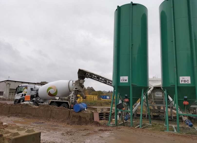 Semimobile Kompaktanlage auf dem Gelände in Grevenkrug. Hier wird der Trommelmischer gerade wieder mit Flüssigboden-Zutaten gefüttert. Die grünen Silos für Zement und Compound haben ein Fassungsvolumen von jeweils 33 cm3. | Foto: B_I/Valdix Semimobile Kompaktanlage auf dem Gelände in Grevenkrug. Hier wird der Trommelmischer gerade wieder mit Flüssigboden-Zutaten gefüttert. Die grünen Silos für Zement und Compound haben ein Fassungsvolumen von jeweils 33 cm3. | Foto: B_I/Valdix