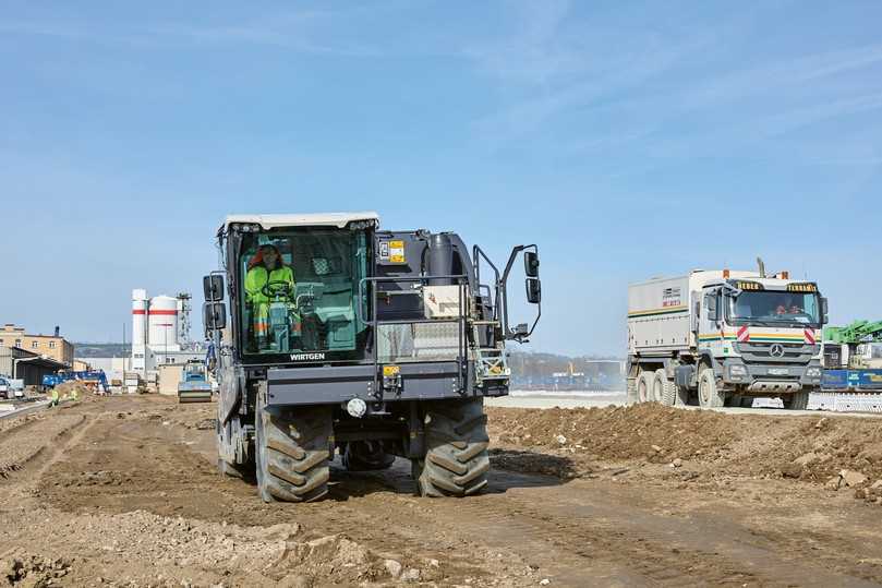Nach dem Recycling kommt die Bodenstabilisierung: Der Wirtgen WRC 240i (links) bricht und durchmischt das Bodenmaterial 50 cm tief, der Streumaster SW 16 MC (rechts) bringt das Zementgemisch auf. | Foto: Wirtgen Group Nach dem Recycling kommt die Bodenstabilisierung: Der Wirtgen WRC 240i (links) bricht und durchmischt das Bodenmaterial 50 cm tief, der Streumaster SW 16 MC (rechts) bringt das Zementgemisch auf. | Foto: Wirtgen Group