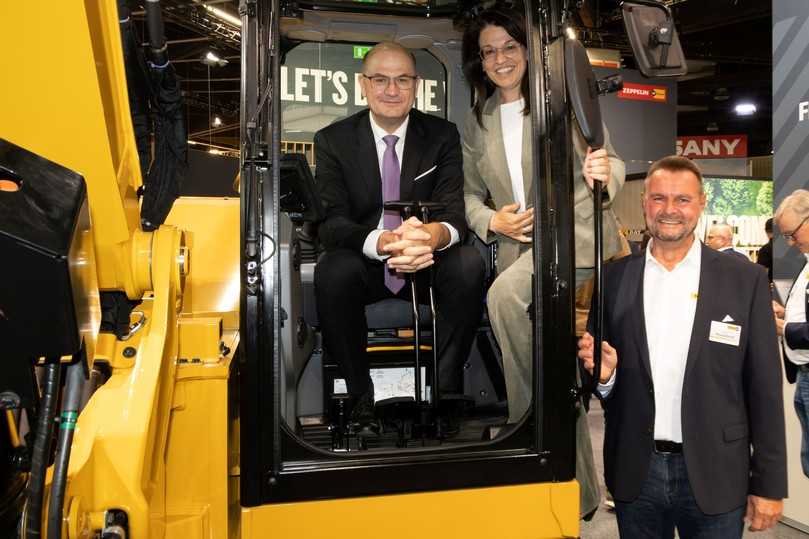 Besuch bei Zeppelin auf der GaLaBau 2026: Bayerns Finanzminister Albert Füracker (links) und Martina Englhardt-Kopf, parlamentarische Staatssekretärin im Bundeslandwirtschaftsministerium, informierten sich bei Messestand-Leiter Oliver Brockschmidt über Cat-Baumaschinen. | Foto: Nürnberg Messe/Frank Boxler