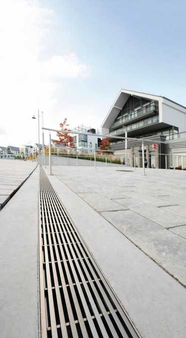 Die von der Promenade aus zu den An- legestellen führenden breiten Rampen werden mit Entwässerungsrinnen trocken gehalten. Die Rinnen sind mit reddot-prämierten Design-Rosten vom Typ Hydra Linearis abgedeckt, die sich durch ihr zeitloses Design gut an die hochwertige Architektur der umliegenden Gebäude anschließen.