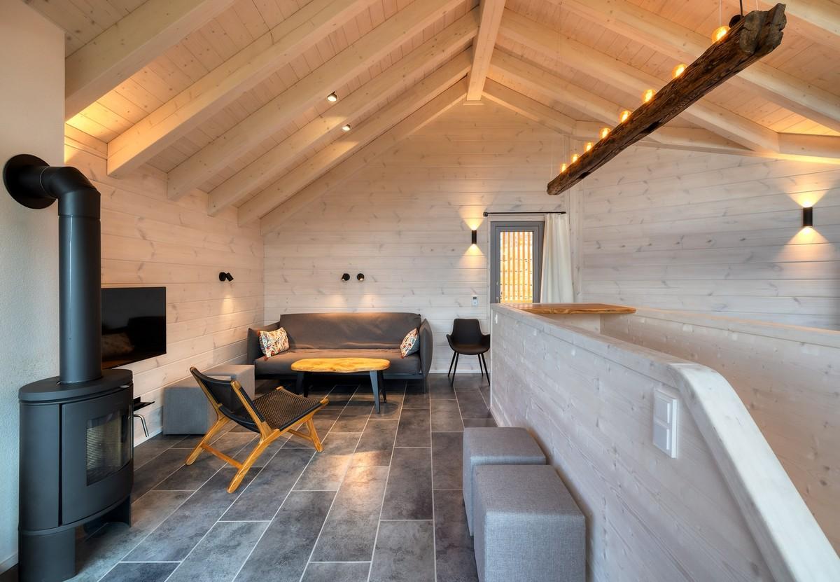 Kreislauffähig gebaut: Auch die Lampe im Wohn- und Essbereich ist wiederverwertet, denn der Balken stammt aus dem abgerissenen Vorgängerhaus. | Foto: Nikolay Kazakov