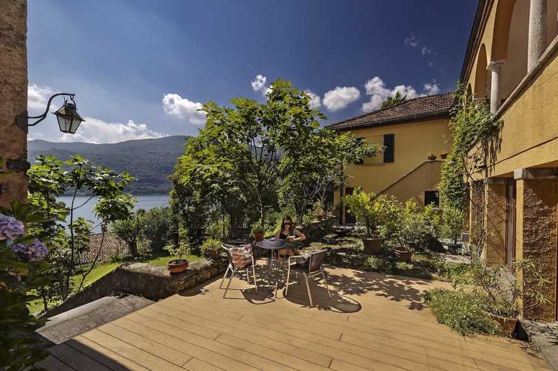 Heute ist die Terrasse der Villa Morcote nicht nur ein Ort zum Entspannen, sondern auch ein Musterbeispiel dafür, wie modernes Material historische Baukultur respektvoll ergänzt. Die Entscheidung für die Diele aus WPC von Naturinform – „Die Naturlinie“ in Eichenbraun – fiel nicht nur aus optischen Gründen. Mit einer langen Lebensdauer, minimalem Pflegeaufwand und einer Farbgebung, die perfekt zur ockergelben Fassade passt, waren die Dielen für die Bauherren die ideale Wahl. | Foto: www.keller-fotografie.de