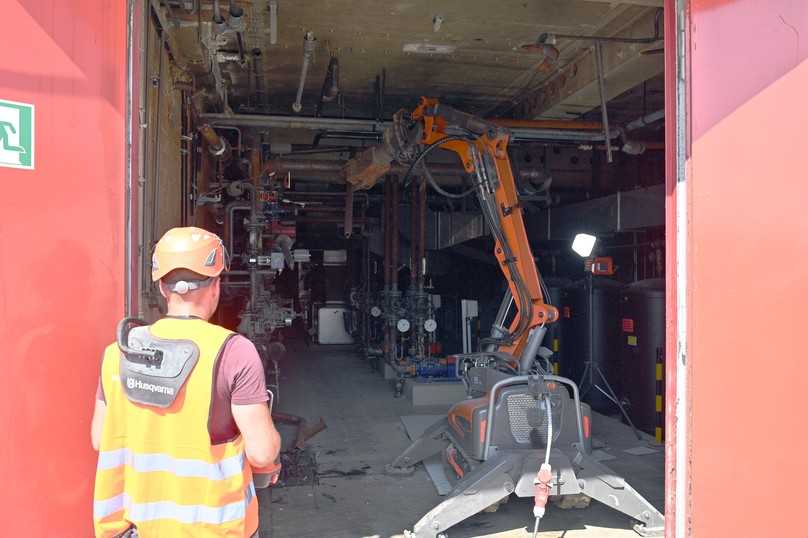 Der ferngesteuerte Ein-Tonnen-Abrissroboter DXR 145 von Husqvarna holt die Metallrohre im Heizungsraum von der Decke und zerkleinert sie für den Abtransport. | Foto: QUATEX