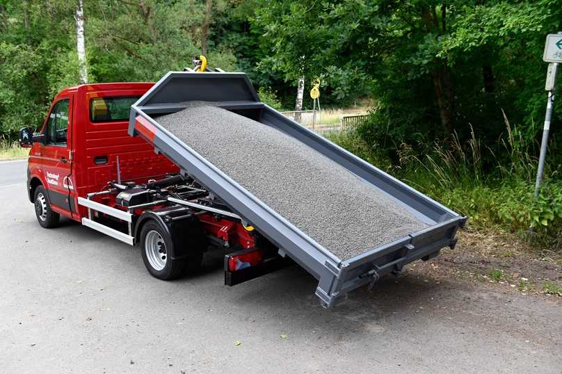 Fast mühelos zieht das Palfinger-Hakengerät mit 5 t Hubkraft die voll beladene Mulde auf das MAN-Fahrgestell. | Foto: QUATEX Fast mühelos zieht das Palfinger-Hakengerät mit 5 t Hubkraft die voll beladene Mulde auf das MAN-Fahrgestell. | Foto: QUATEX