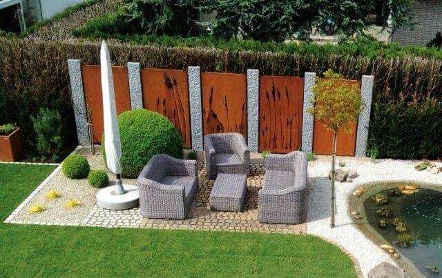 Sichtschutzwand Vista: Gartenmetall‐Motivwände aus Cortenstahl zwischen Granitstelen: Der Wechsel zwischen Naturstein und Edelrost liegt im Trend. | Foto: Gartenmetall, Bequiri – Garten‐ und Landschaftsbau, Schwalbach