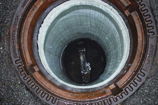 Blick in einen sanierten Schacht. Die Auskleidung des Gerinnes und die Anbindung der Zuläufe erfolgt nachträglich per Hand mit GFK-Laminat.