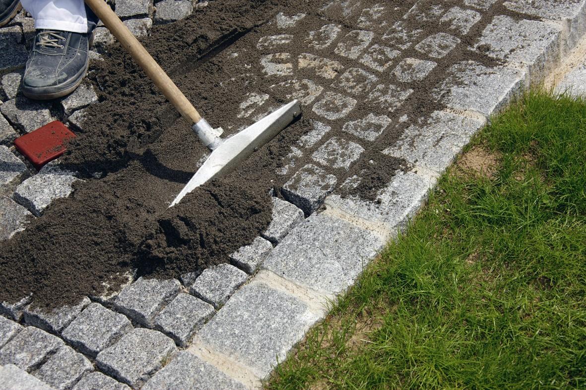 Verfugen von Natursteinpflaster mit dem drainfähigen PUR-Pflasterfugenmörtel PCI Pavifix PU und der bereits fertig verfugten Randsteine mit dem Zement-Pflastermörtel PCI Pavifix CEM ROC. | Foto: PCI Augsburg GmbH