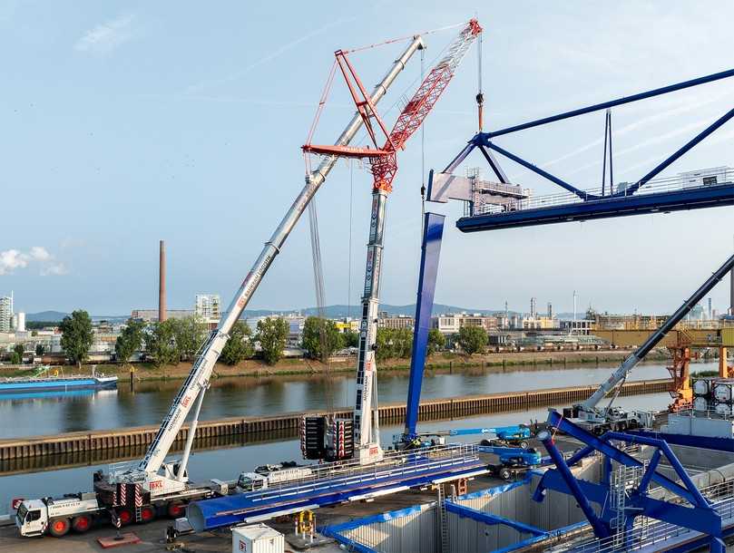 Kniffelig: Mit Fingerspitzengefühl und präziser Steuerung schwenkte der Autokranfahrer des LTM 1300-6.2 über den LTM 1450-8.1, der mit einem 28-Meter-Wippausleger den Hauptträger hielt, und platzierte die Stütze exakt an der vorgesehenen Stelle. | Foto: Boris Golz Fotografie GmbH / BKL Baukran Logistik GmbH