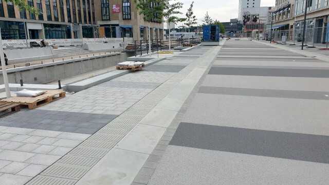 Die grau gestreifte Asphaltfläche wurde exakt an die Grautöne des Betonsteinpflasters angepasst.