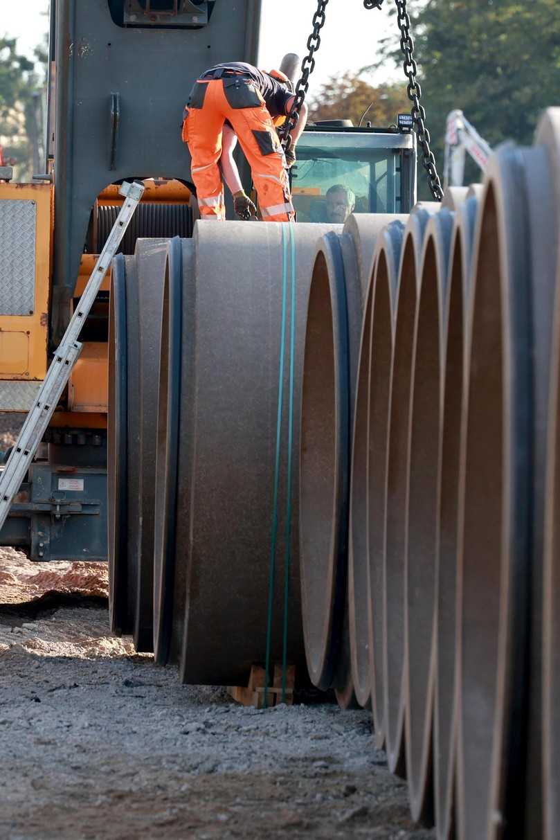 Sicherheit an erster Stelle: Ein Bauarbeiter befestigt die Ketten des Krans am Rohr, um es sicher in die Kanaltrasse zu heben. | Foto: Meyer-Polycrete