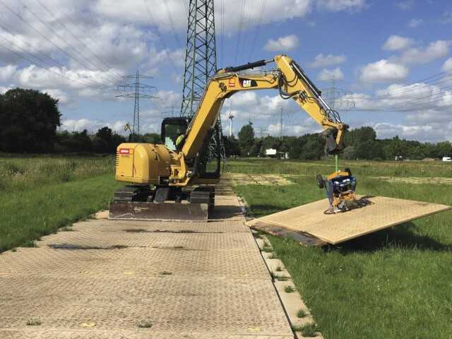 Wenn es ganz schnell gehen soll: Für einen raschen Auf- und Abbau einer Dura-Base-Zufahrt setzt das TPA Montage-Team hier einen Raupenbagger mit Vakuum-Plattenheber ein. Wenn es ganz schnell gehen soll: Für einen raschen Auf- und Abbau einer Dura-Base-Zufahrt setzt das TPA Montage-Team hier einen Raupenbagger mit Vakuum-Plattenheber ein.
