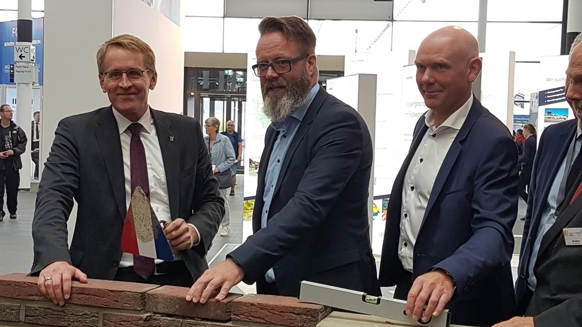 Traditioneller Kellenschlag: Ministerpräsident Daniel Günther (l.) und Wirtschaftsminister Claus Ruhe Madsen eröffneten die Nordbau, unterstützt von Torben Kleinfeldt, Managing Director der Friedrich Vorwerk Gruppe (r.). | Foto: bb