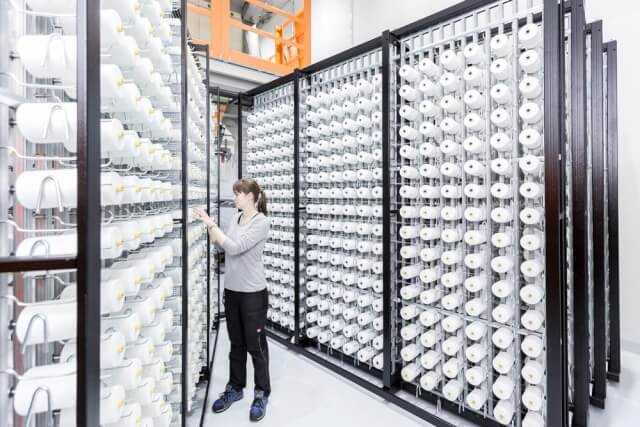 Im Fraunhofer-Projektzentrum Wolfsburg steht eine spezielle Doppelgreifer-Webmaschine, auf der auch die Flachsfasern verwebt werden können. Hier überprüft eine Mitarbeiterin die Garnspannung. | Foto: Marek Kruszewski Im Fraunhofer-Projektzentrum Wolfsburg steht eine spezielle Doppelgreifer-Webmaschine, auf der auch die Flachsfasern verwebt werden können. Hier überprüft eine Mitarbeiterin die Garnspannung. | Foto: Marek Kruszewski