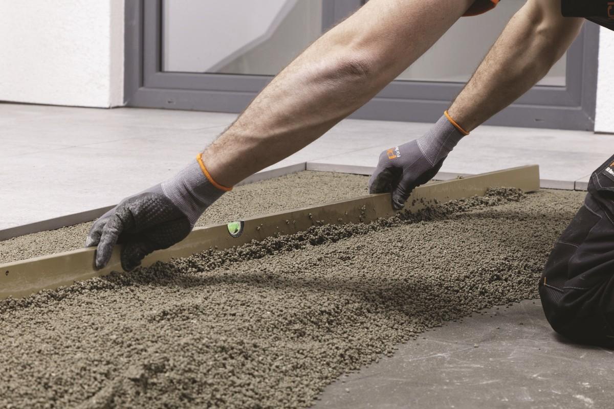 Abziehen des aufgebrachten Drain- und Verlegemörtels PCI Pavifix DM auf einer Terrasse mit Outdoorkeramik. | Foto: PCI Augsburg GmbH