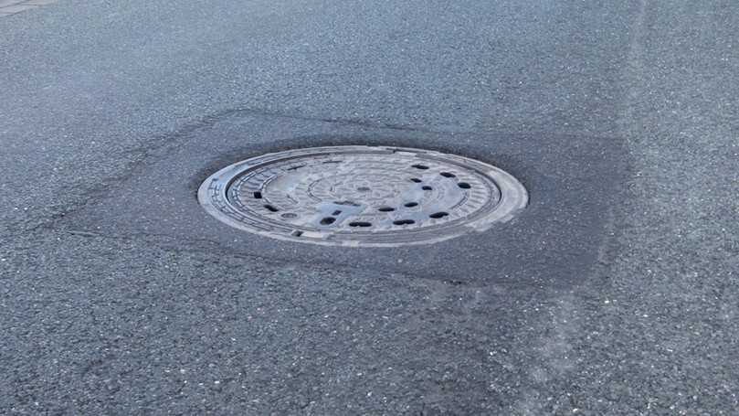Hier sind Fehler beim Einbau passiert: Im Asphalt eingesunkener einwalzbarer Rahmen, Setzung von Deckel im Rahmen. | Foto: Gütegemeinschaft Entwässerungstechnik e.V. (GET)