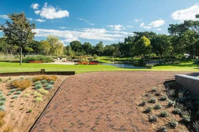 Ein ganz besonderer Garten mit gerumpelten Pflasterklinkern als Auffahrt