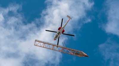 Helikopter fliegt Spezialkran von Liebherr aufs Dach