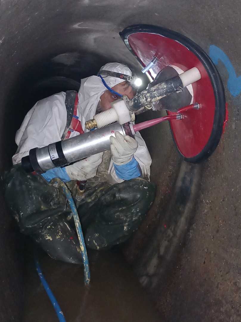 Ein Mitarbeiter injiziert das Harz über eine Öffnung in die Ringnut. Hier wird es angepresst bis es ausgehärtet ist. | Foto: Kanaltechnik Schuster