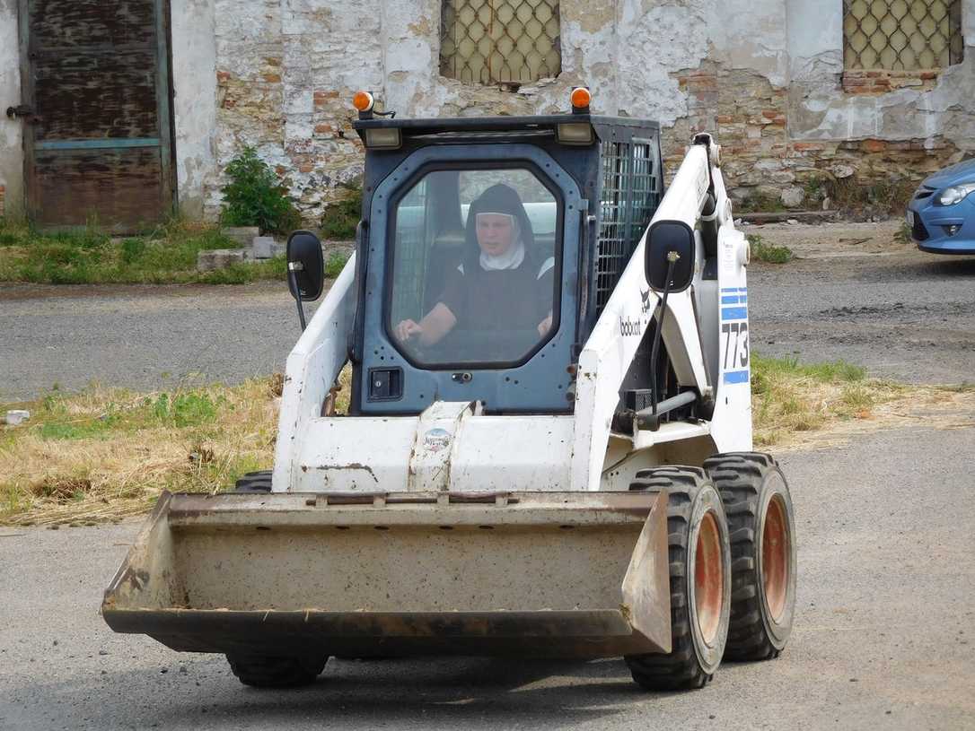 Nonnen fahren mit Bobcat-Lader im Kloster Nonnen fahren mit Bobcat-Lader im Kloster
