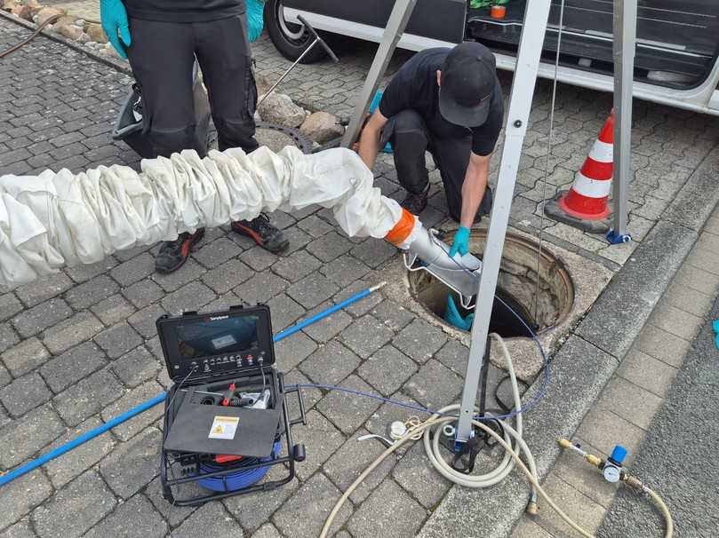 Einführen des Umlenkbogens mit montierter Kamera über den Schacht in den Hauptkanal | Foto: A. zu Eulenburg