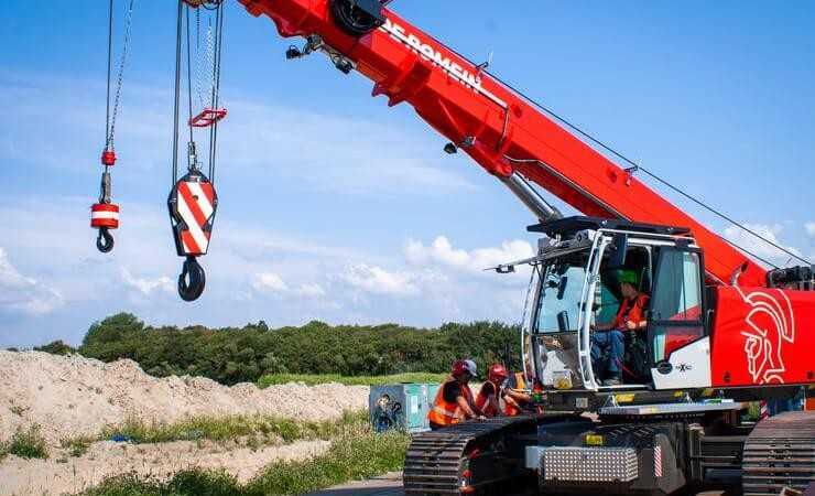 Rot mit Römerkopf: der Raupen-Teleskopkran Sennebogen 653e im Corporate Design der De Romein Group – und mit zweiter Kranwinde. Rot mit Römerkopf: der Raupen-Teleskopkran Sennebogen 653e im Corporate Design der De Romein Group – und mit zweiter Kranwinde.