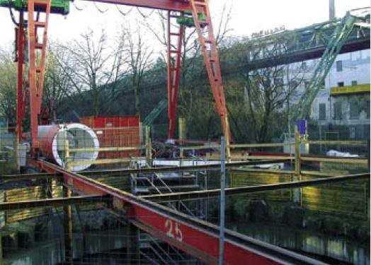 Portalkran über der Pressgrube – im Hintergrund die Wuppertaler Schwebebahn