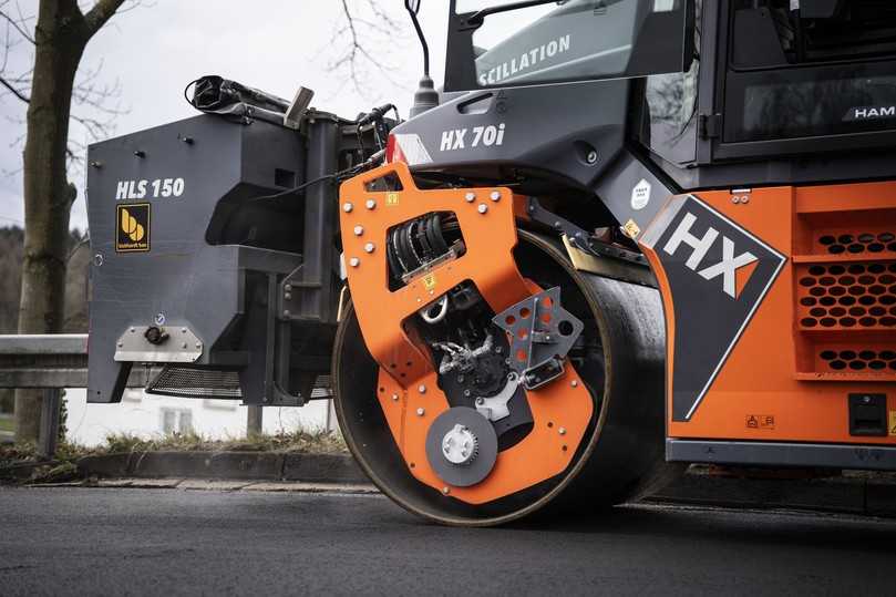Für eine optimale Anfangsgriffigkeit wird bei der Verdichtung Splitt gestreut und eingearbeitet. | Foto: Wirtgen Group