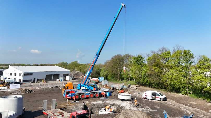 Der E-Autokran von Liebherr versetzt schwere Betonschächte. | Foto: Strabag