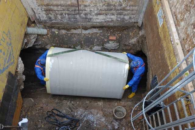 Die bis zum 2,35 m langen GFK-Rohre werden in die 5,50 m tiefe Baugrube auf dem Klärwerksgelände heruntergelassen.