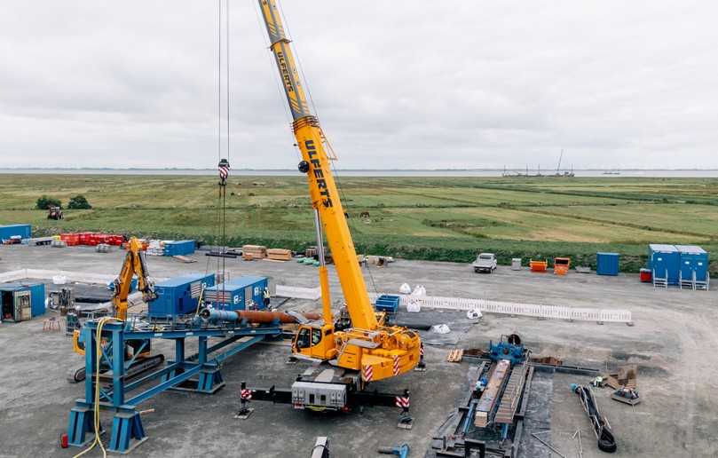 Die Baustelle ‚Am Leuchtturm‘ während des Einbaus des zweiten Casings im Juli 2025 - im Hintergrund das Arbeitsponton im Watt | Foto: Tracto Die Baustelle ‚Am Leuchtturm‘ während des Einbaus des zweiten Casings im Juli 2025 - im Hintergrund das Arbeitsponton im Watt | Foto: Tracto