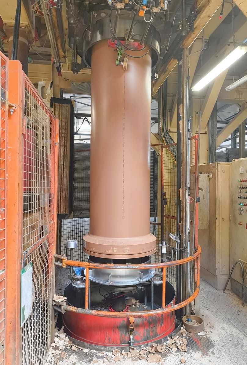 Hier wird ein Muffenrohr vertikal extrudiert. Anschließend wird es auf einen Trocknerwagen zum Weitertransport gesetzt. | Foto: B_I/Valdix