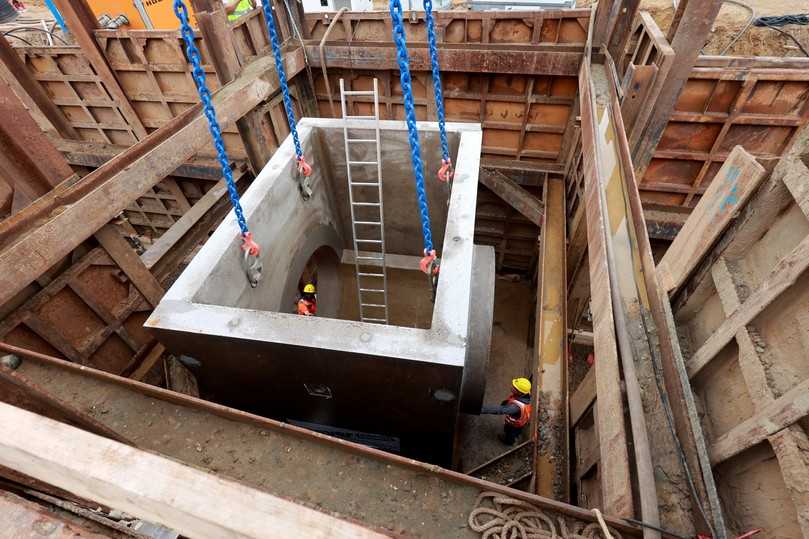 Teamwork unter der Erde: Fachkräfte der Echterhoff Bau GmbH positionieren ein Schachtbauwerk passgenau in der tiefen Baugrube. | Foto: Meyer-Polycrete