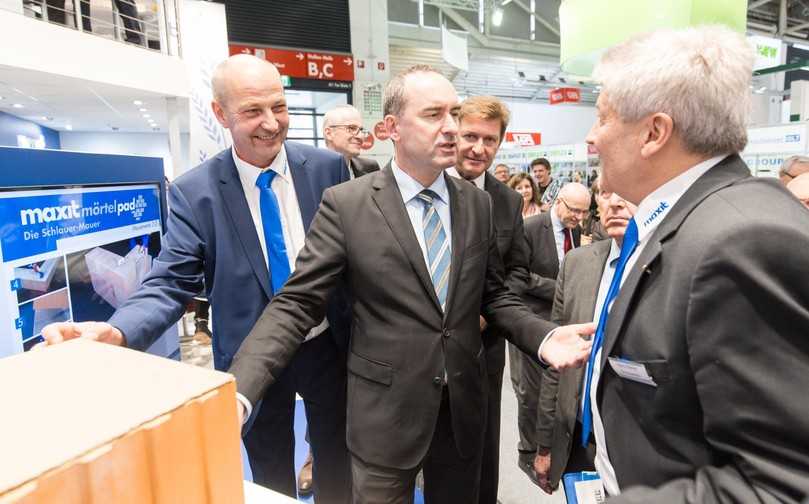 Von den Vorzügen des „Mörtelpads“ überzeugte sich auf der letzten BAU auch Bayerns Wirtschaftsminister Hubert Aiwanger (Mitte) im Gespräch mit Maxit-Chef Hans-Dieter Groppweis (r.). | Foto: Maxit Von den Vorzügen des „Mörtelpads“ überzeugte sich auf der letzten BAU auch Bayerns Wirtschaftsminister Hubert Aiwanger (Mitte) im Gespräch mit Maxit-Chef Hans-Dieter Groppweis (r.). | Foto: Maxit