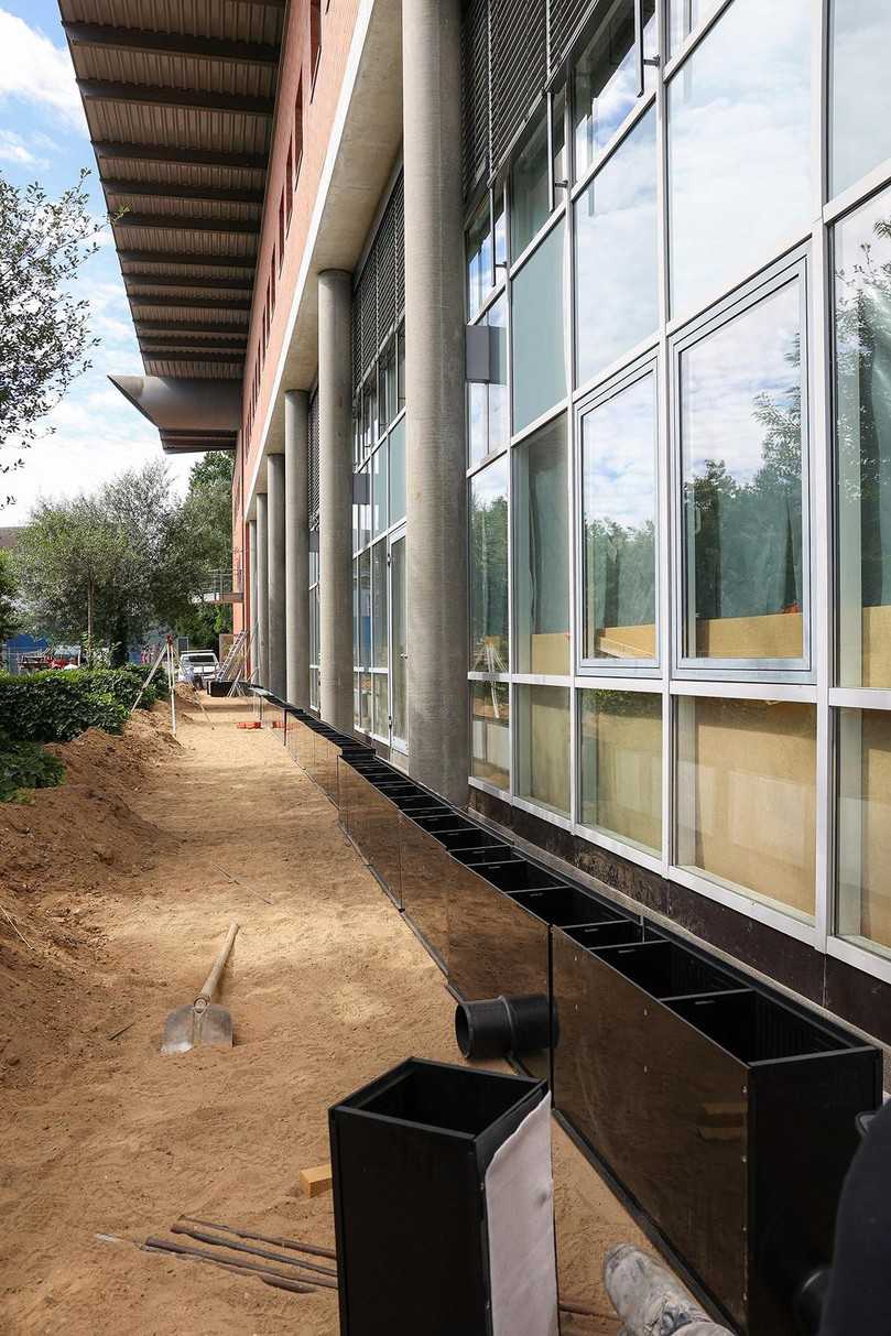 Nach dem Aushub des Grabens wurde ein Planum hergestellt und mit 5 bis 8 cm Magerbeton versehen. Darauf erfolgte das exakte Setzen und Ausrichten der Rinne entlang der Glasfassade. | Foto: Funke Industrie Nach dem Aushub des Grabens wurde ein Planum hergestellt und mit 5 bis 8 cm Magerbeton versehen. Darauf erfolgte das exakte Setzen und Ausrichten der Rinne entlang der Glasfassade. | Foto: Funke Industrie