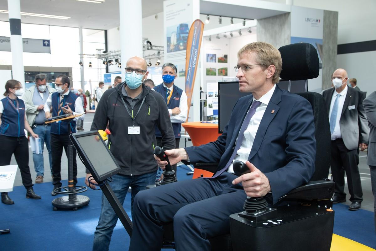 Landesvater am Steuer: Der schleswig-holsteinische Ministerpräsident Daniel Günther besuchte bei der NordBau 2021 den Stand des VDBUM und fuhr eine Übungseinheit am Baumaschinen-Simulator. | Foto: NordBau Landesvater am Steuer: Der schleswig-holsteinische Ministerpräsident Daniel Günther besuchte bei der NordBau 2021 den Stand des VDBUM und fuhr eine Übungseinheit am Baumaschinen-Simulator. | Foto: NordBau