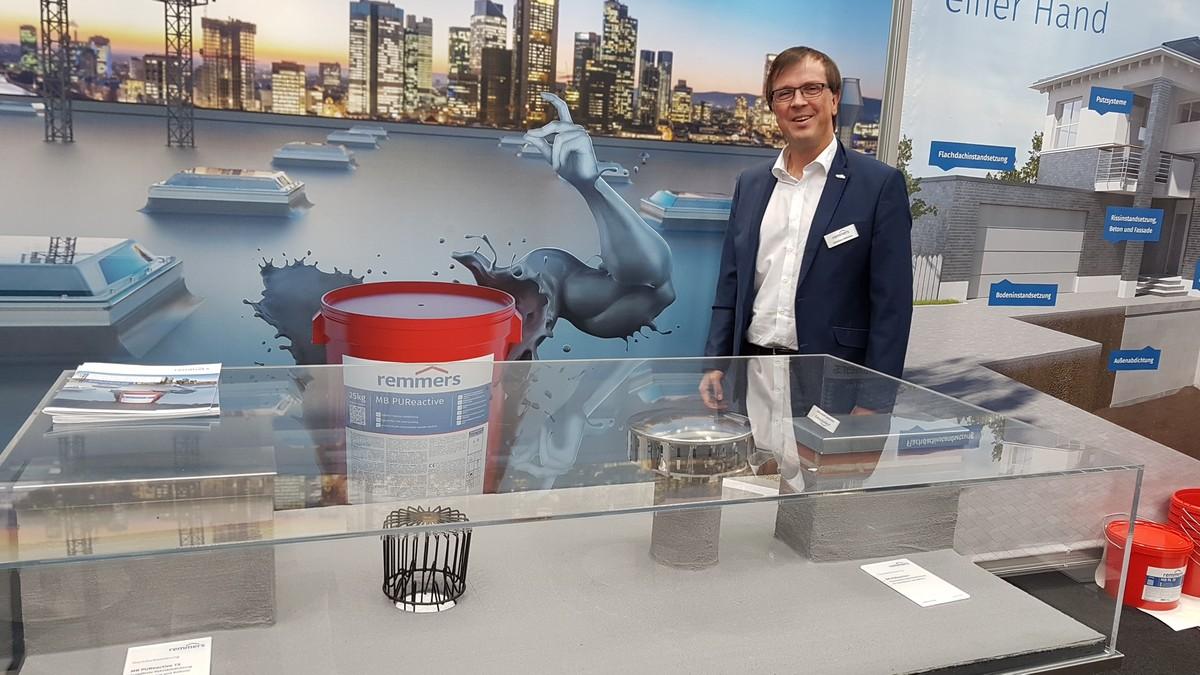 Remmers-Marketingleiter Christian Behrends ist zum ersten Mal auf der Nordbau. Eines der Highlights auf dem Stand in Halle 1 ist die rissüberbrückende Flachdachabdichtung „PUReactive“, mit der sich zum Beispiel Hallendächer günstig sanieren lassen. | Foto: bb
