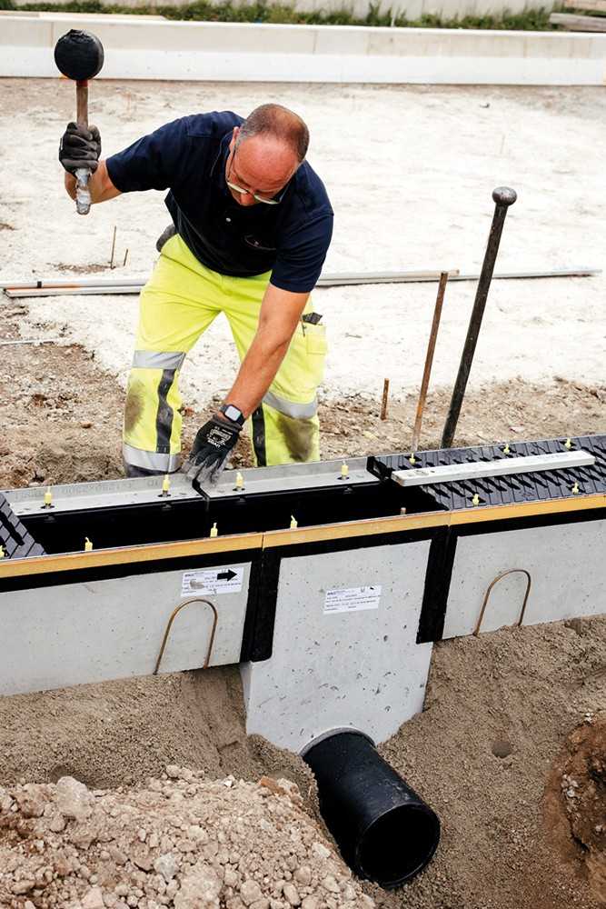 Montage eines Liniensinkkastens mit PEHD-Auskleidung und Rohrstutz. Von dort wird das Wasser erst gefiltert, dann in Rigolen weitergeleitet. | Foto: Birco