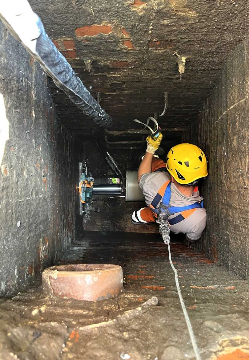 Vor dem Einzug wird das neue Rohr im Schacht positioniert und anschließend mittels Hydrauliktechnik in das Altrohr eingeschoben. | Foto: Sanierungstechnik Dommel