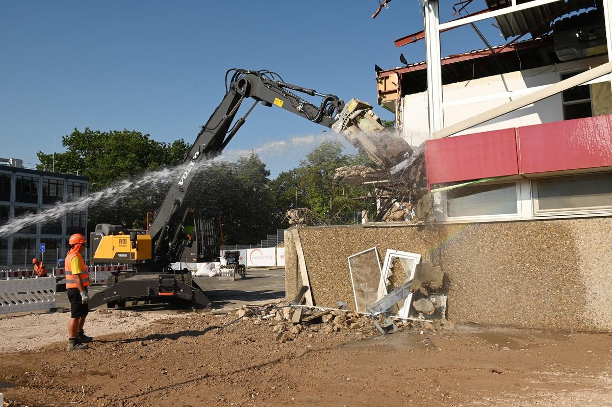 Der Volvo Umschlagbagger EW240 Electric MH hängt am Stromkabel und reißt emissionsfrei das Siemens-Gebäude in Erlangen ab. | Foto: QUATEX